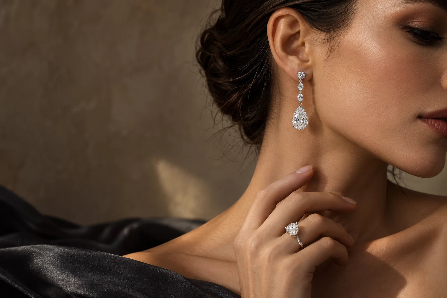 Silver pear-cut diamond earrings and a diamond ring, worn with charcoal silk